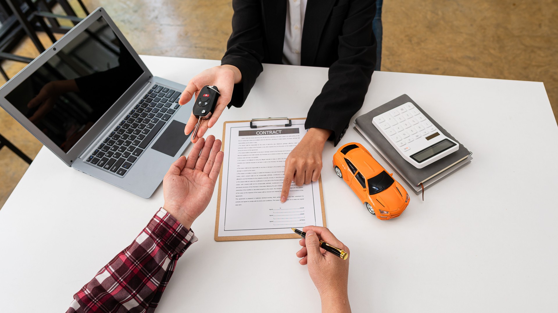 The car salesman hands the keys to the customers who have signed the legal car sales contract. Sell the finished car and deliver the keys at the table in the top view sales office.